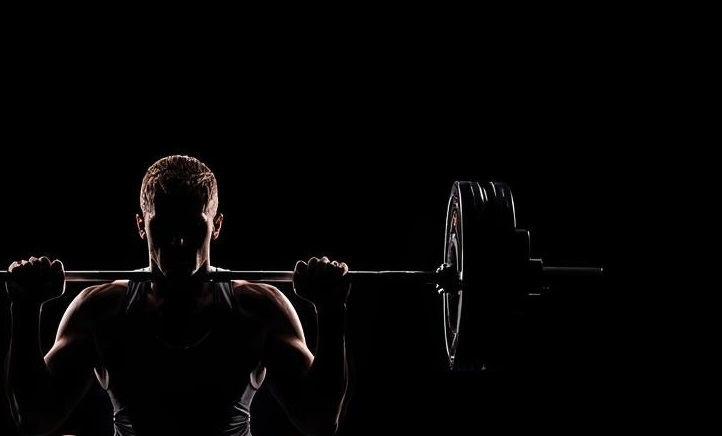 A guy holding barbell rod preparing for squats.